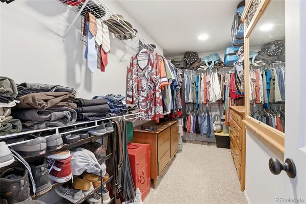 a view of walk in closet with clothes and shoes