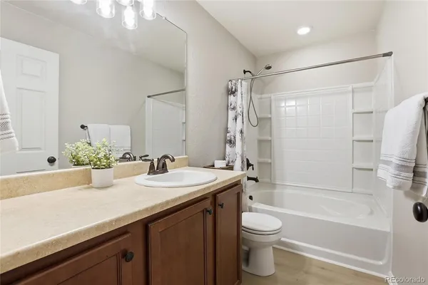 a bathroom with a double vanity sink toilet mirror and shower