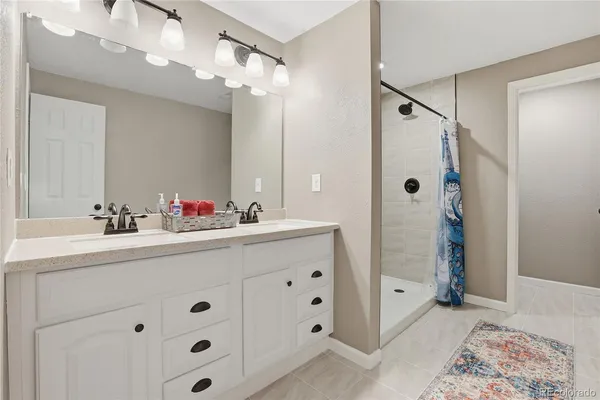 a bathroom with a double vanity sink mirror and shower