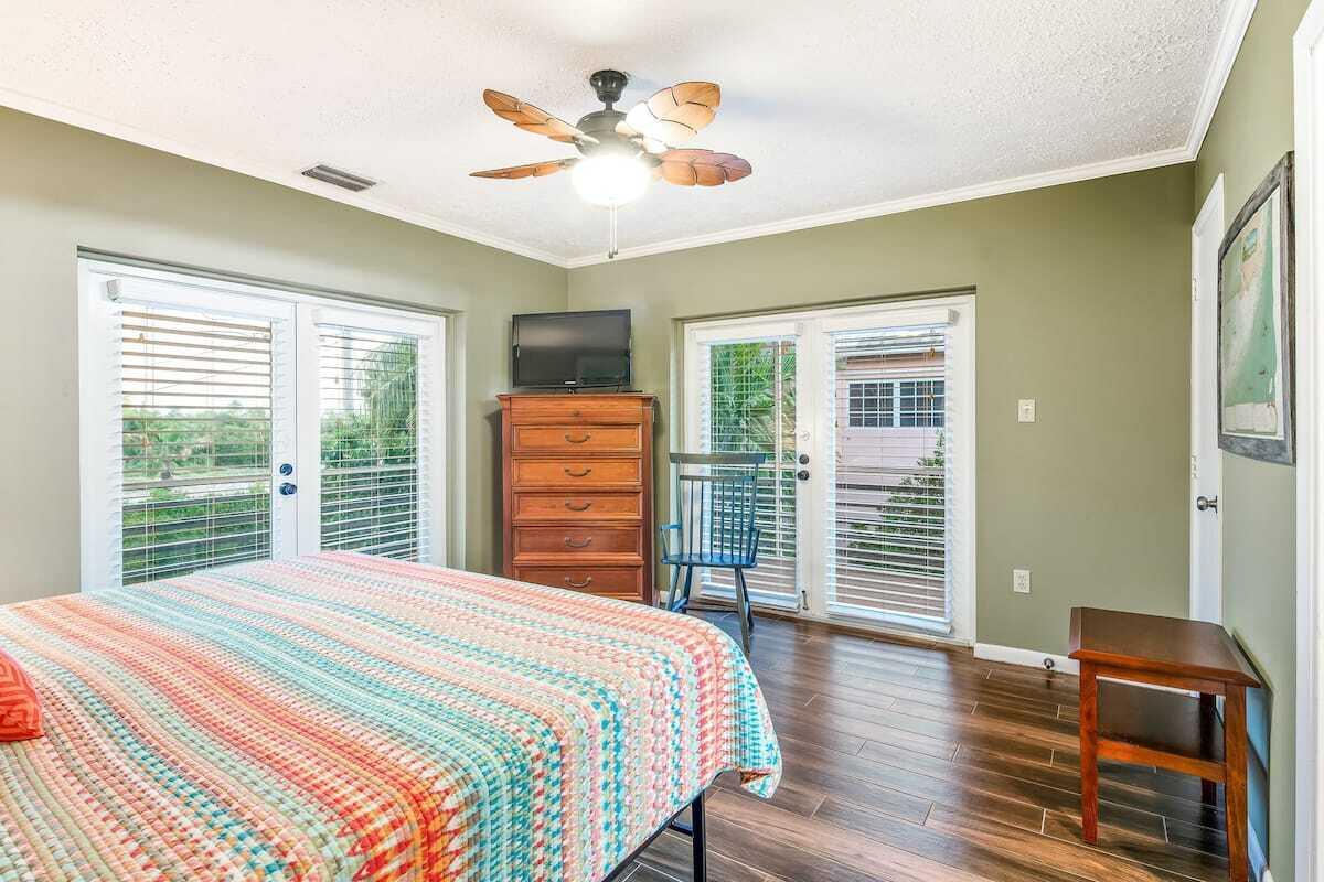 1495 Copa D Oro Marathon, FL 33050 - Photo 17 of 41 a bedroom with a large bed a chandelier and a flat tv screen