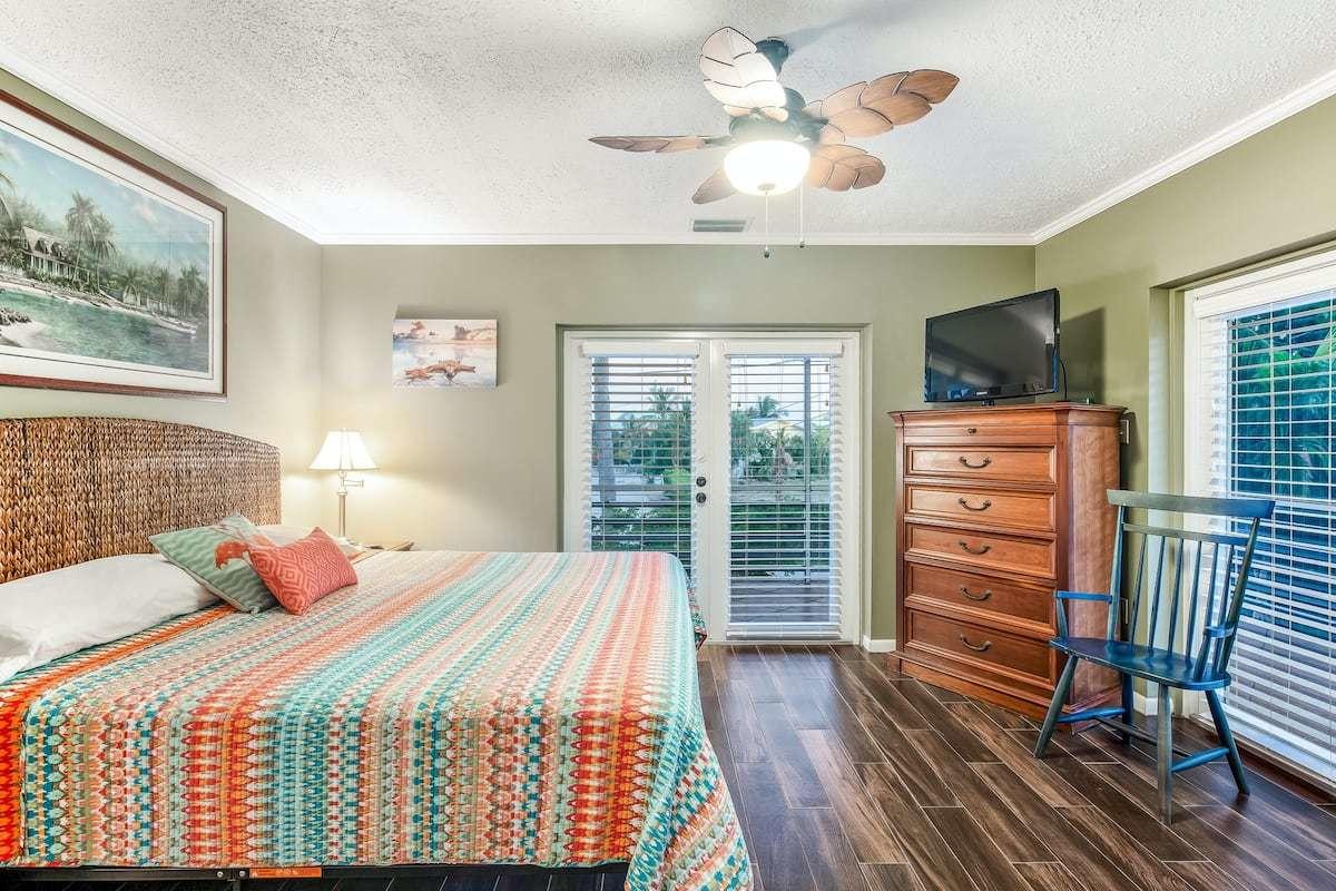 1495 Copa D Oro Marathon, FL 33050 - Photo 20 of 41 a bedroom with a bed a dresser and a flat screen tv