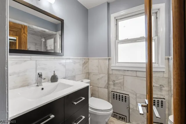 a bathroom with a sink mirror toilet and vanity