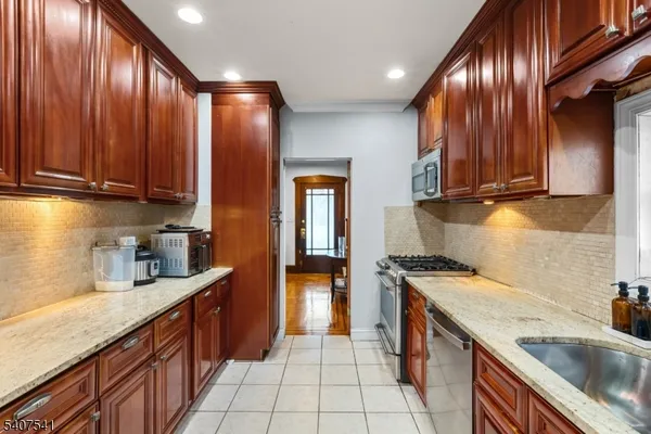 a kitchen with stainless steel appliances granite countertop wooden cabinets a sink and dishwasher