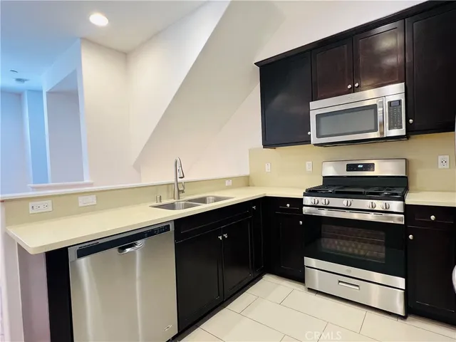 a kitchen with stainless steel appliances a sink and a microwave