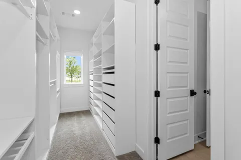 a view of a hallway with wooden floor and closet