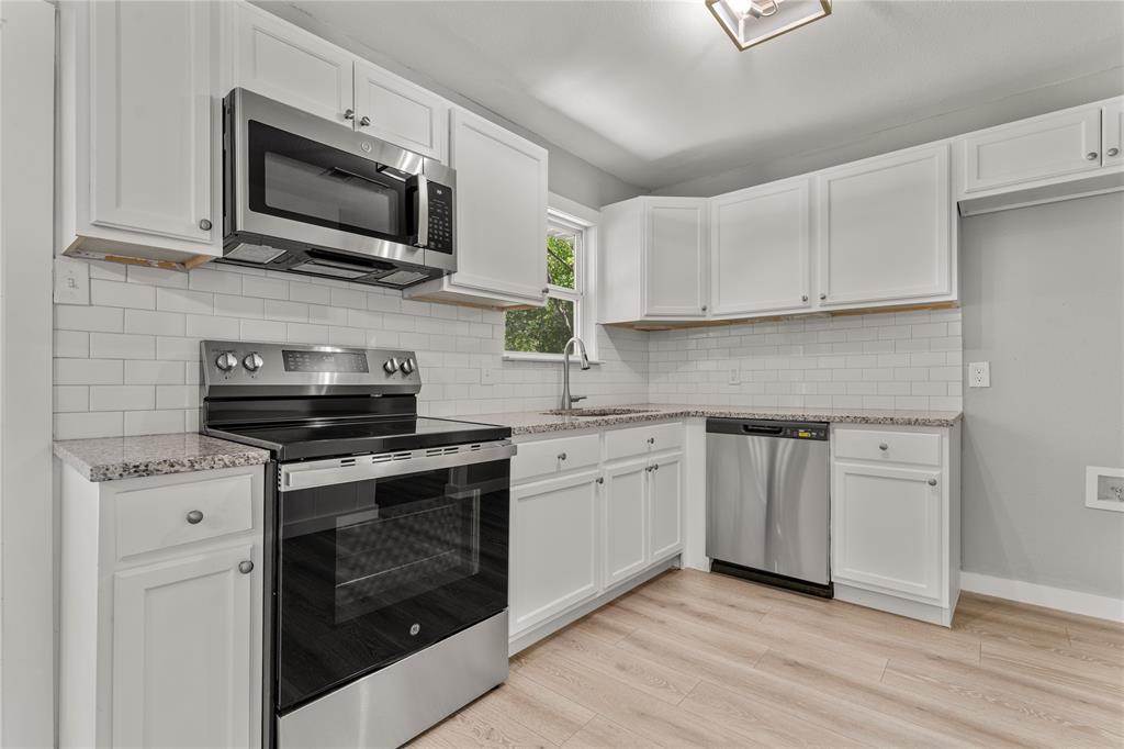 709 North Rita Street Lacy-Lakeview, TX 76705 - Photo 22 of 32 a kitchen with stainless steel appliances granite countertop a stove a sink and a microwave