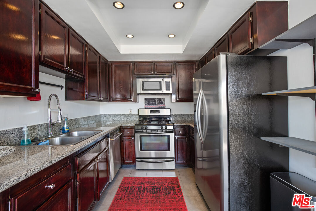 432 South Hamel Road, Unit 302 Los Angeles, CA 90048 - Photo 8 of 20 a kitchen with stainless steel appliances granite countertop a sink a stove and a refrigerator