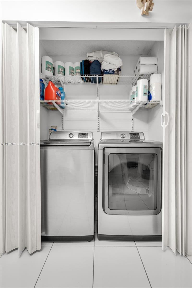 8405 Northwest 8th Street, Unit 1072 Miami, FL 33126 - Photo 16 of 33 a utility room with stainless steel appliances granite countertop a stove a washer and dryer