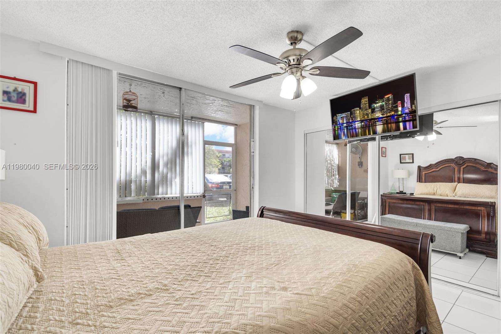 8405 Northwest 8th Street, Unit 1072 Miami, FL 33126 - Photo 17 of 33 a bedroom with a large bed and a chandelier