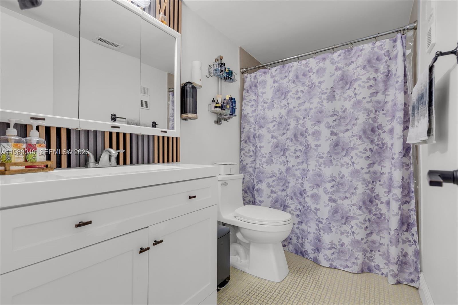 8405 Northwest 8th Street, Unit 1072 Miami, FL 33126 - Photo 18 of 33 a bathroom with a toilet and a shower curtain