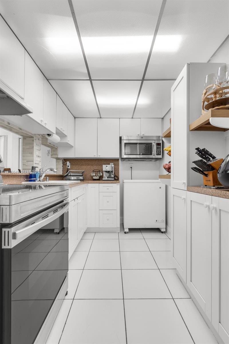 8405 Northwest 8th Street, Unit 1072 Miami, FL 33126 - Photo 22 of 33 a kitchen with cabinets and steel stainless steel appliances