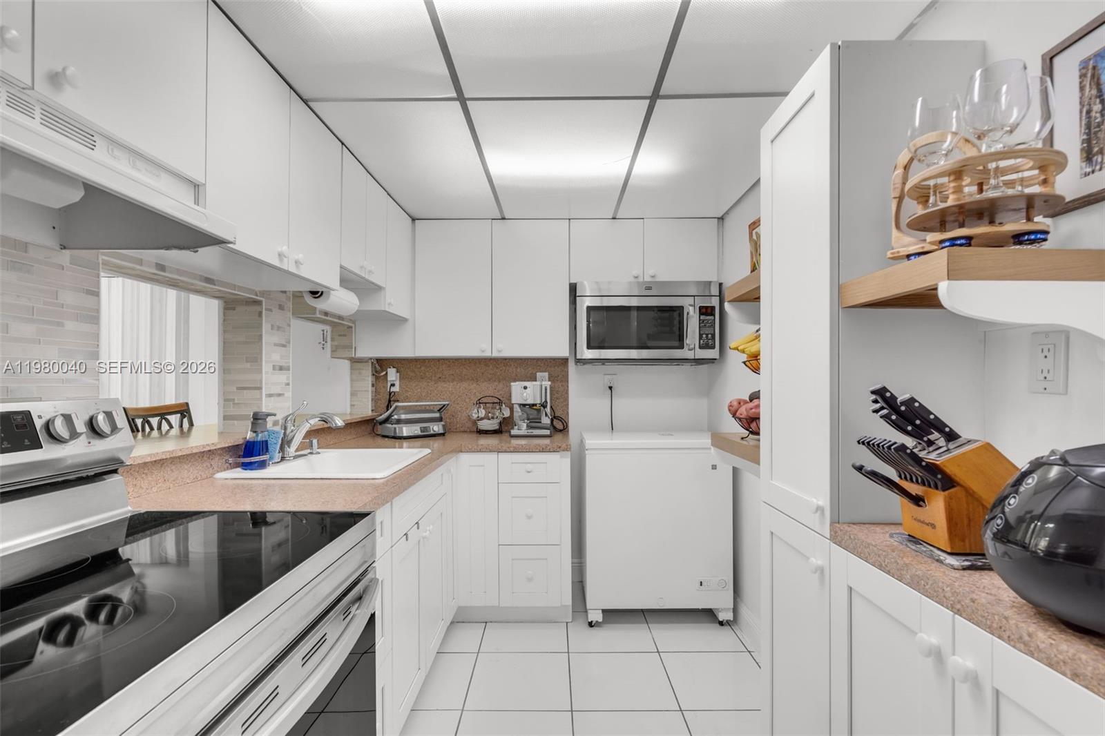 8405 Northwest 8th Street, Unit 1072 Miami, FL 33126 - Photo 24 of 33 a kitchen with a sink appliances and cabinets