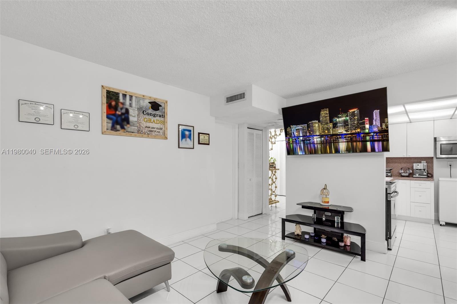 8405 Northwest 8th Street, Unit 1072 Miami, FL 33126 - Photo 26 of 33 a living room with furniture and a flat screen tv