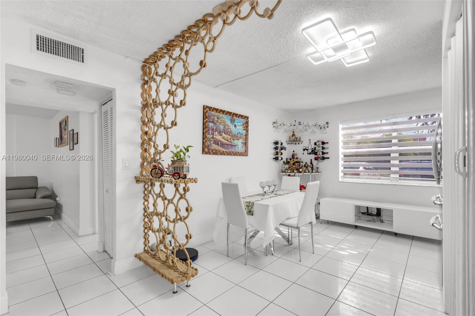 8405 Northwest 8th Street, Unit 1072 Miami, FL 33126 - Photo 28 of 33 a view of a dining room with furniture and a chandelier
