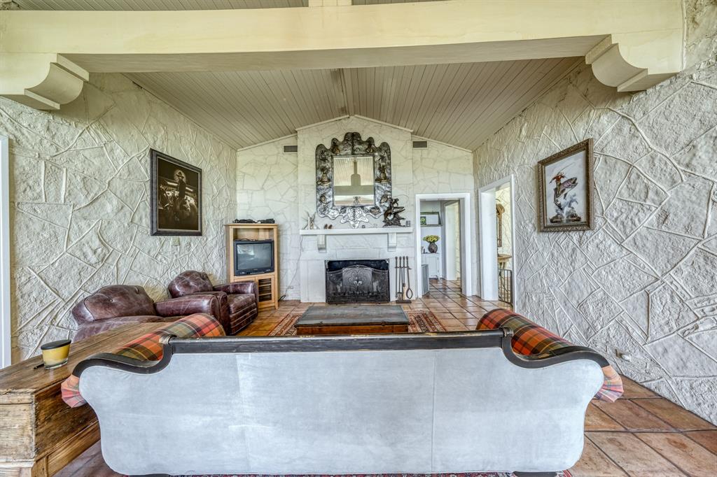 8601 Star Hollow Road Lipan, TX 76462 - Photo 5 of 40 a living room with furniture a fireplace and a chandelier