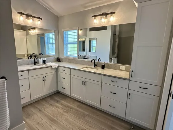 a spacious bathroom with double sink and a mirror