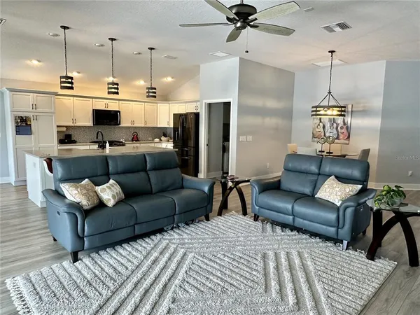 a living room with furniture and a chandelier