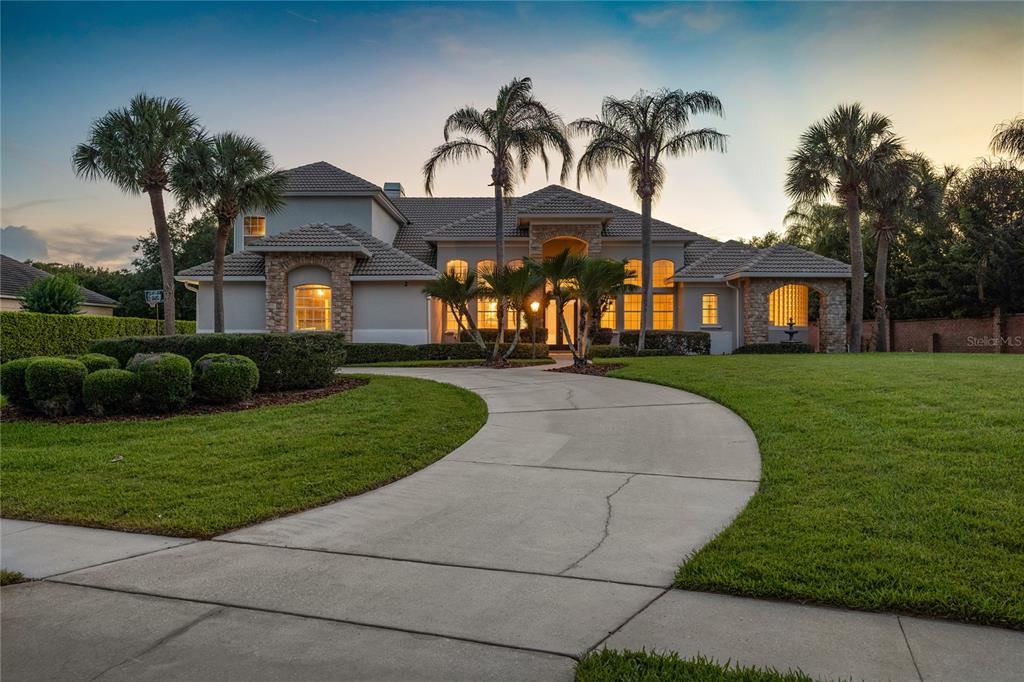 a front view of a house with a garden and trees