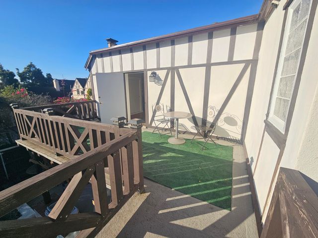a backyard of a house with table and chairs and potted plants