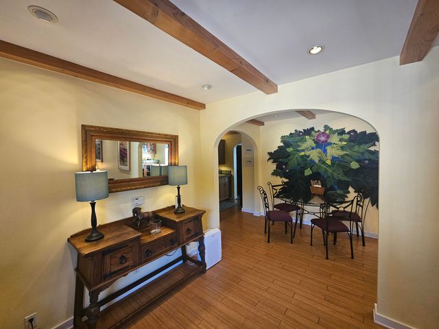 a living room with furniture a dining table and chairs with wooden floor