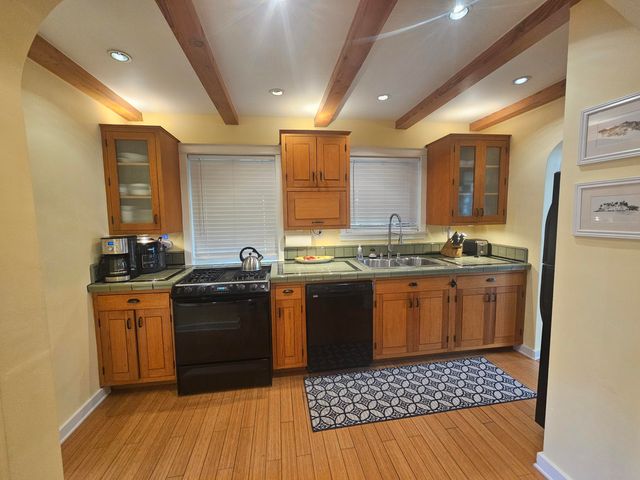 a kitchen with stainless steel appliances granite countertop a stove a sink dishwasher and a refrigerator