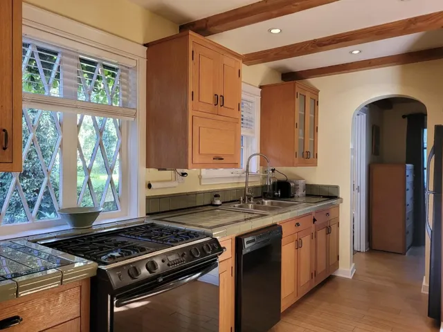 a kitchen with a stove a sink and a window