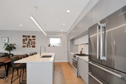 a kitchen with stainless steel appliances kitchen island a refrigerator sink and stove