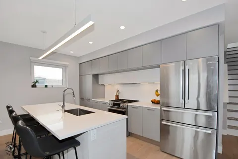 a kitchen with a sink stainless steel appliances and refrigerator