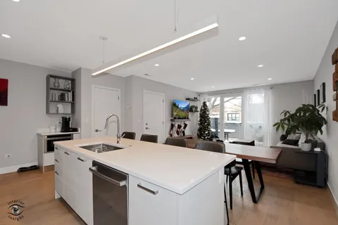 a view of kitchen with stainless steel appliances kitchen island a sink table and chairs in it