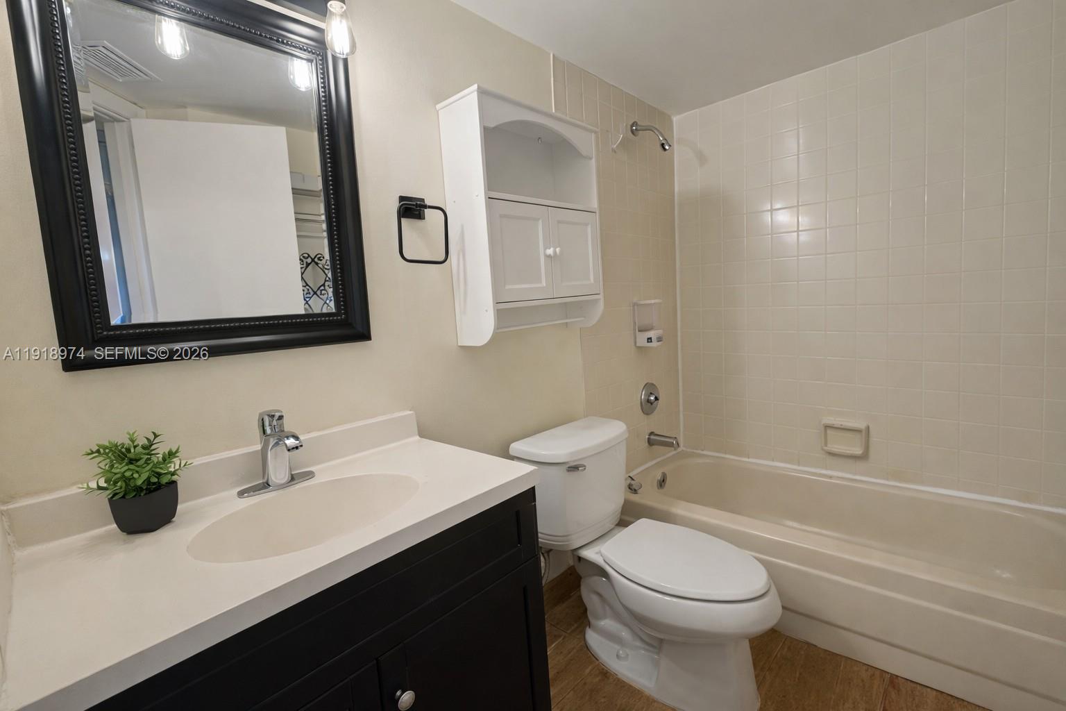 8801 Wiles Road, Unit 307 Coral Springs, FL 33067 - Photo 11 of 16 a bathroom with a sink a toilet a mirror and shower