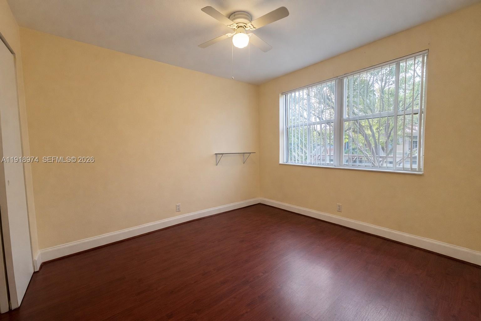 8801 Wiles Road, Unit 307 Coral Springs, FL 33067 - Photo 12 of 16 a view of an empty room with wooden floor and a window