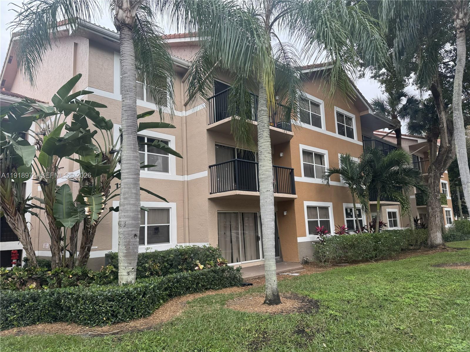 8801 Wiles Road, Unit 307 Coral Springs, FL 33067 - Photo 14 of 16 a front view of a house with a yard