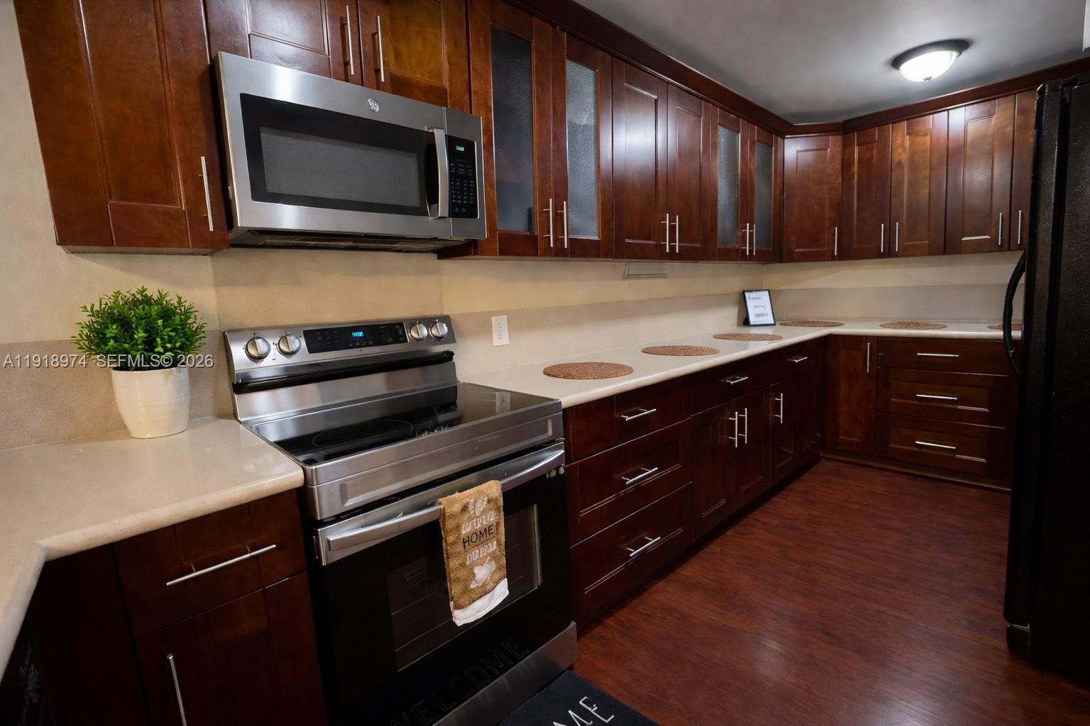 8801 Wiles Road, Unit 307 Coral Springs, FL 33067 - Photo 2 of 16 a kitchen with a sink stove and microwave