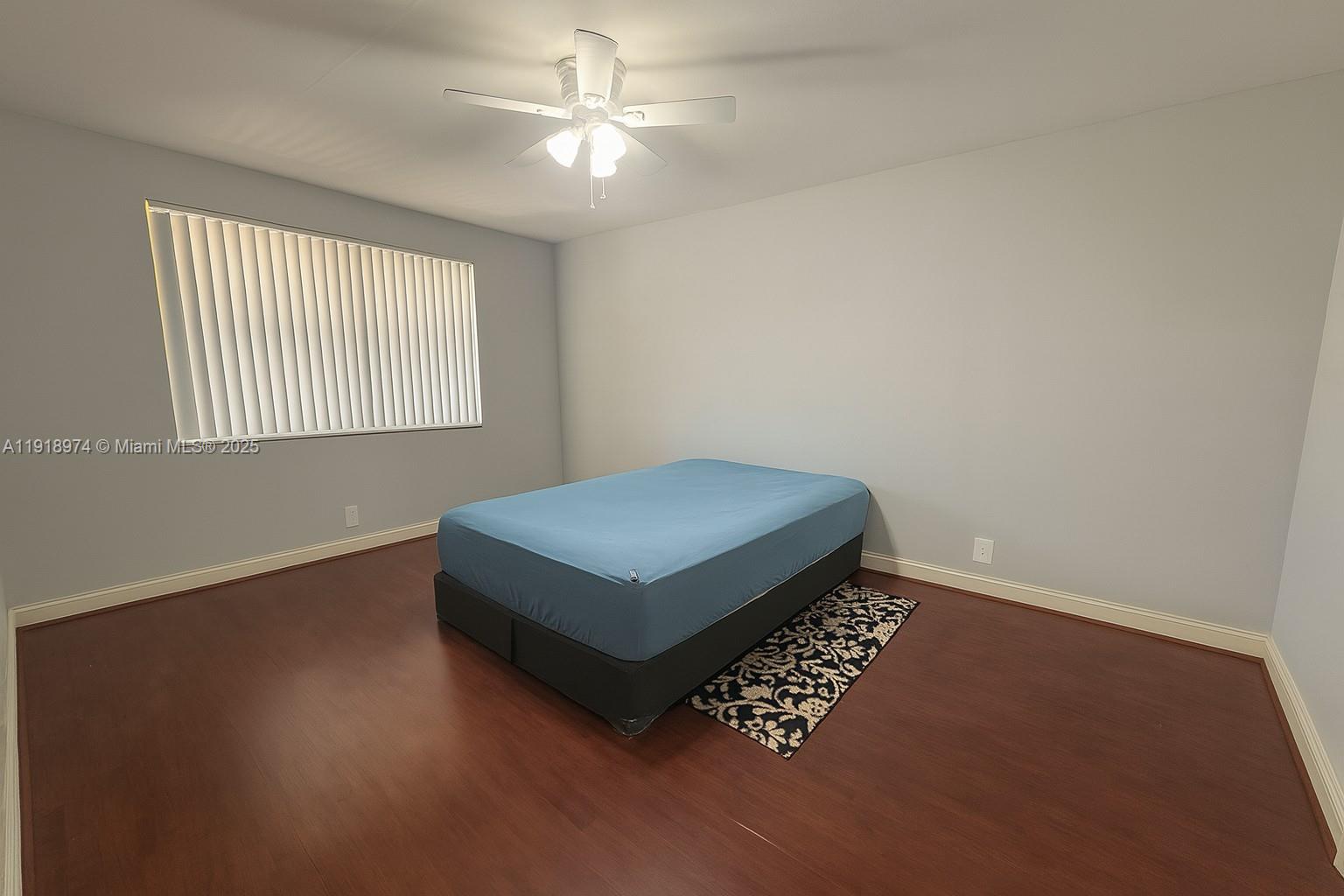 8801 Wiles Road, Unit 307 Coral Springs, FL 33067 - Photo 4 of 10 a living room with hard wood floors and a ceiling fan