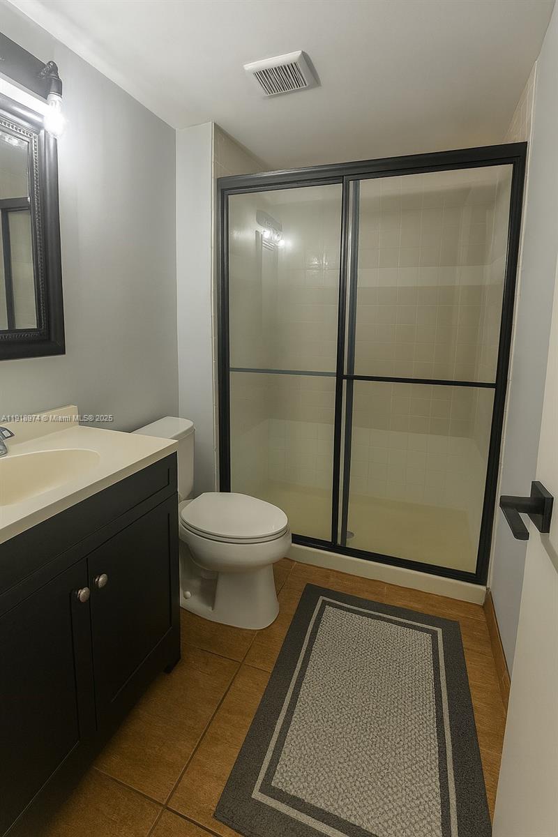 8801 Wiles Road, Unit 307 Coral Springs, FL 33067 - Photo 5 of 10 a bathroom with a toilet a sink and a mirror