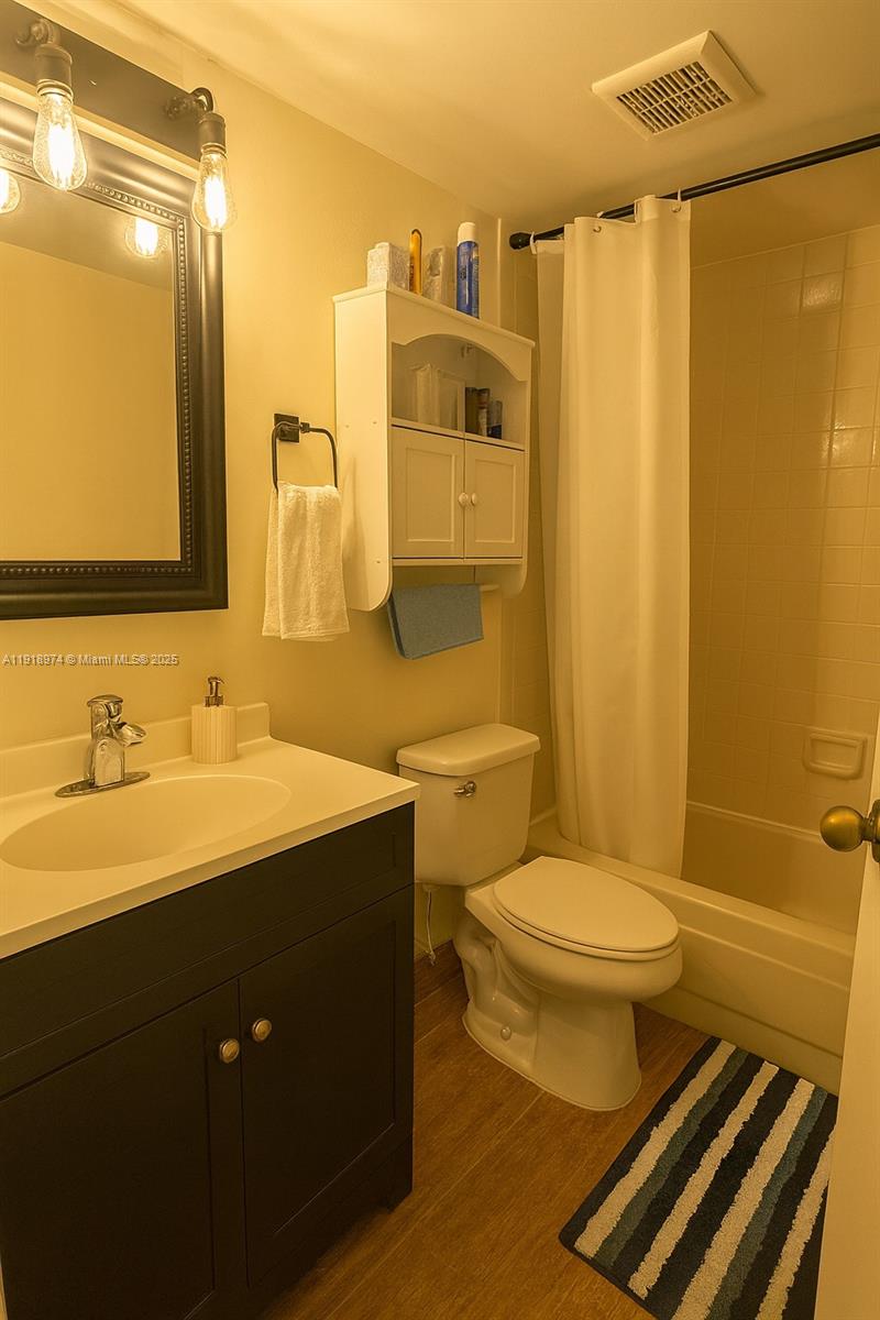 8801 Wiles Road, Unit 307 Coral Springs, FL 33067 - Photo 8 of 10 a bathroom with a sink and a mirror