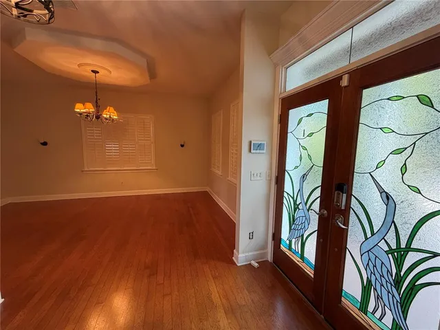 a view of an empty room with window and wooden floor