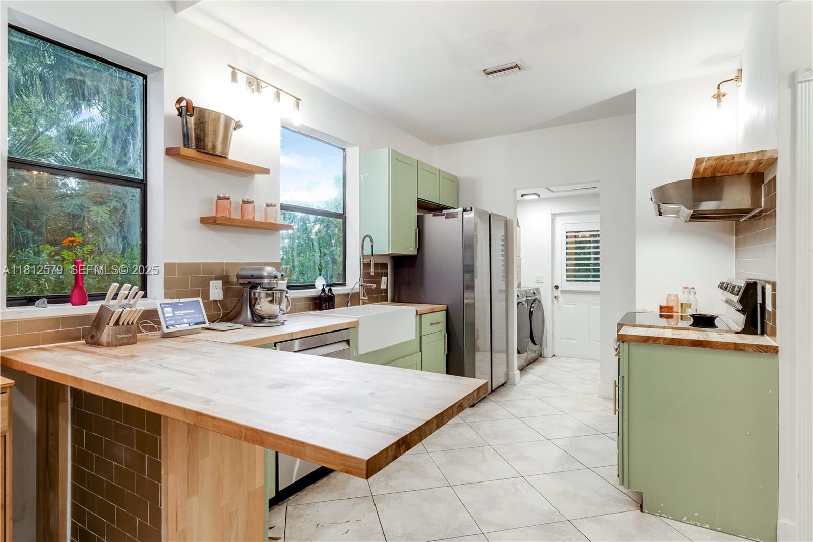 7900 Southwest Springhaven Avenue Indiantown, FL 34956 - Photo 11 of 38 a kitchen with stainless steel appliances a refrigerator a sink a stove and island