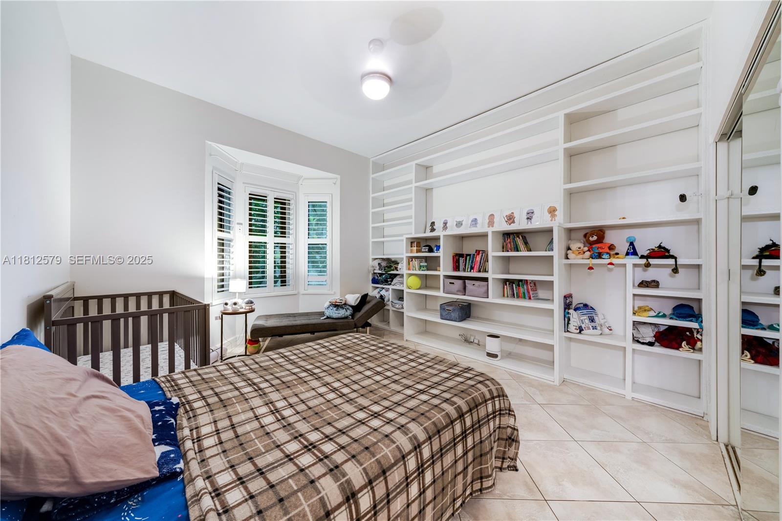 7900 Southwest Springhaven Avenue Indiantown, FL 34956 - Photo 16 of 38 a bedroom with a bed and a book shelf