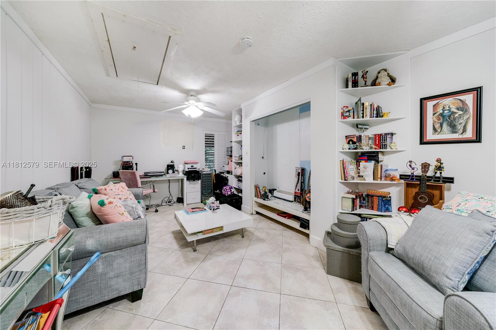 7900 Southwest Springhaven Avenue Indiantown, FL 34956 - Photo 18 of 38 a living room with furniture and a bookshelf