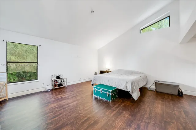 a bed sitting in a spacious bedroom next to a window