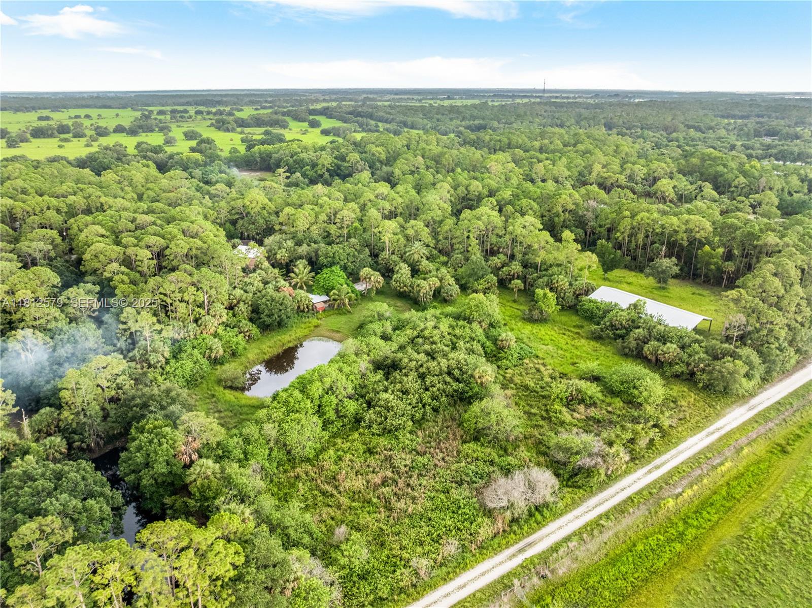 7900 Southwest Springhaven Avenue Indiantown, FL 34956 - Photo 32 of 38 an aerial view of residential houses with outdoor space and trees