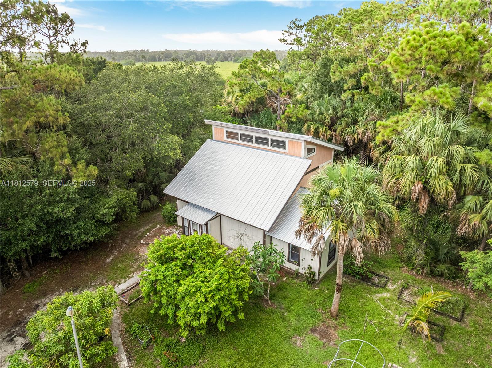 7900 Southwest Springhaven Avenue Indiantown, FL 34956 - Photo 33 of 38 a view of a garden with large trees