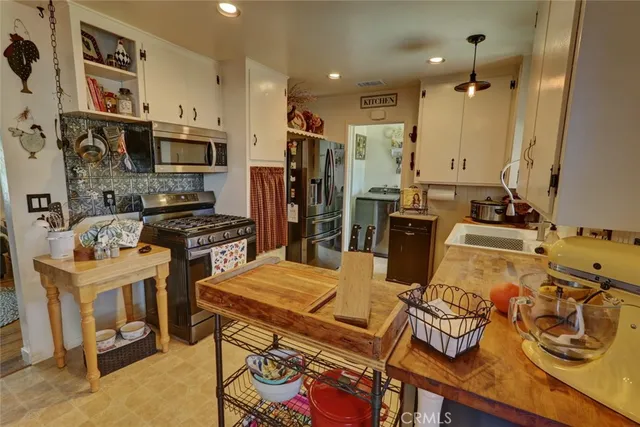 a kitchen with stainless steel appliances kitchen island granite countertop a sink stove and refrigerator