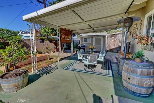 a view of a patio with table and chairs potted plants and floor to ceiling window