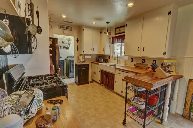 a kitchen that has a lot of cabinets in it and stainless steel appliances