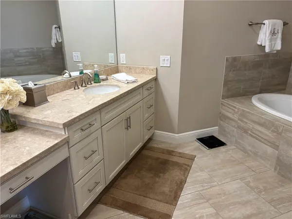 a bathroom with a granite countertop sink and a mirror