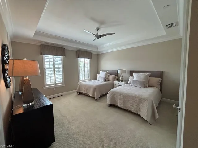 a spacious bedroom with two beds and a lamp