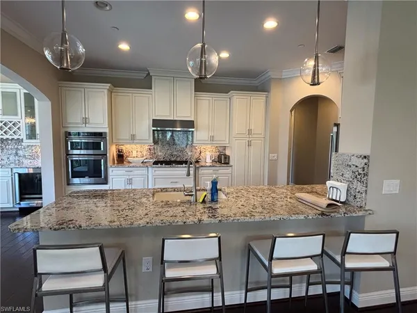 a kitchen with kitchen island granite countertop a table and chairs in it