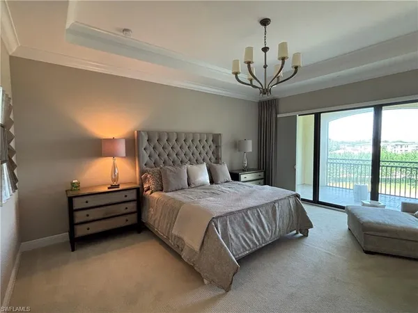 a bedroom with a bed and a chandelier